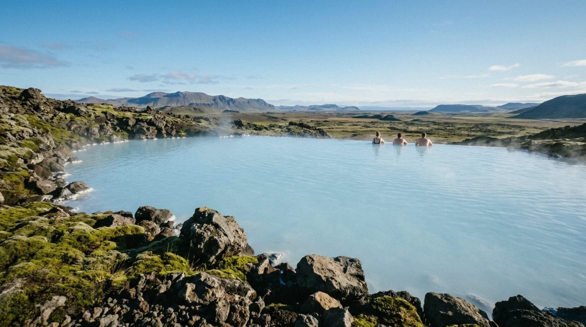 A wide Icelandic geothermal lagoon with bathers at the far edge, the kind of pool families compare before booking